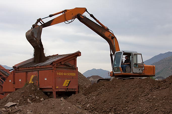 Loading raw material into the topsoil screener by Robert Nelson Construction in Salem, UT.